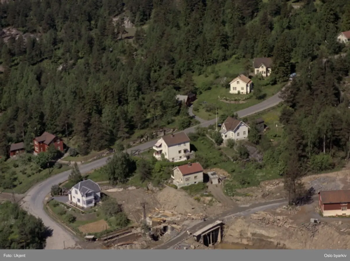 Byggingen av Ammerud t-banestasjon. Veien i bildet er Lilloseterveien. Dagens Ammerudvei går omtrent der veien krysser tunnelåpningen. (Flyfoto)