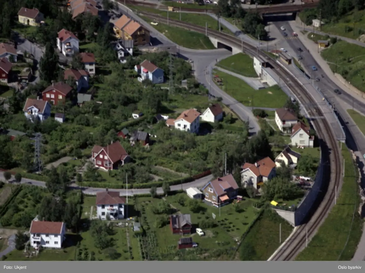 Villabebyggelse i Bekkeveien. Høyenhall stasjon (Lambertseterbanen) langs Store Ringvei (Adolf Hedins vei). Østensjøveien inn fra høyre og videre under Østensjøbanen. Høyenhallveien starter ved undergang til Lambertseterbanen og kryss med Bekkeveien. (Flyfoto)
