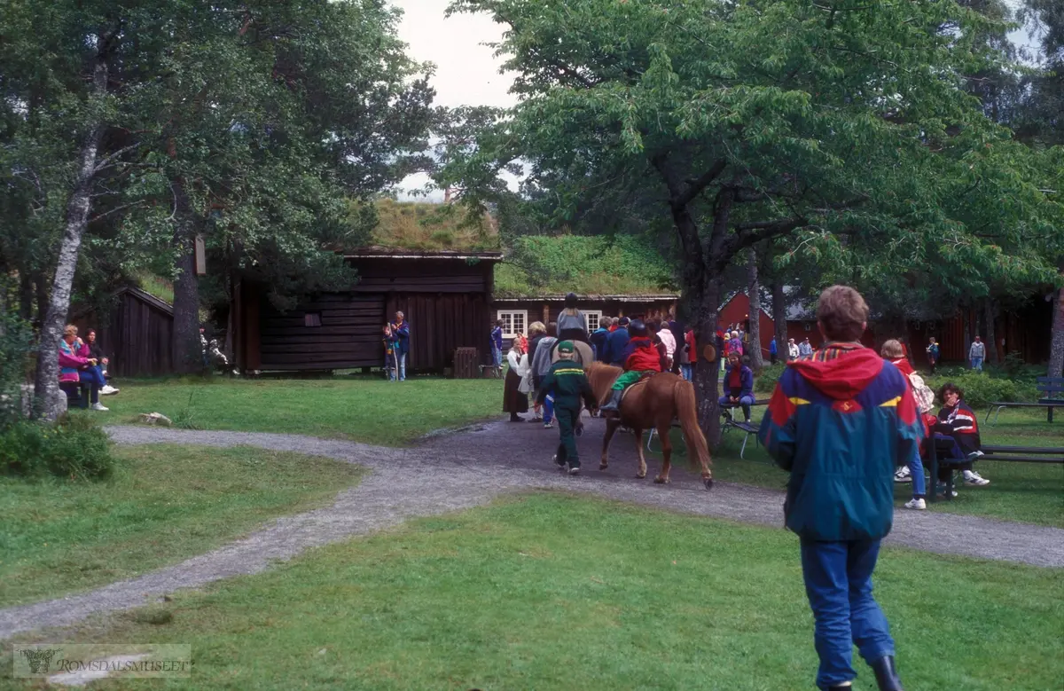 Olsok på Romsdalsmuseet i 1996. .Aktører fra Vistdal bondekvinnelag..Hammervoll-stua og Kleivestabburet i bakgrunnen.