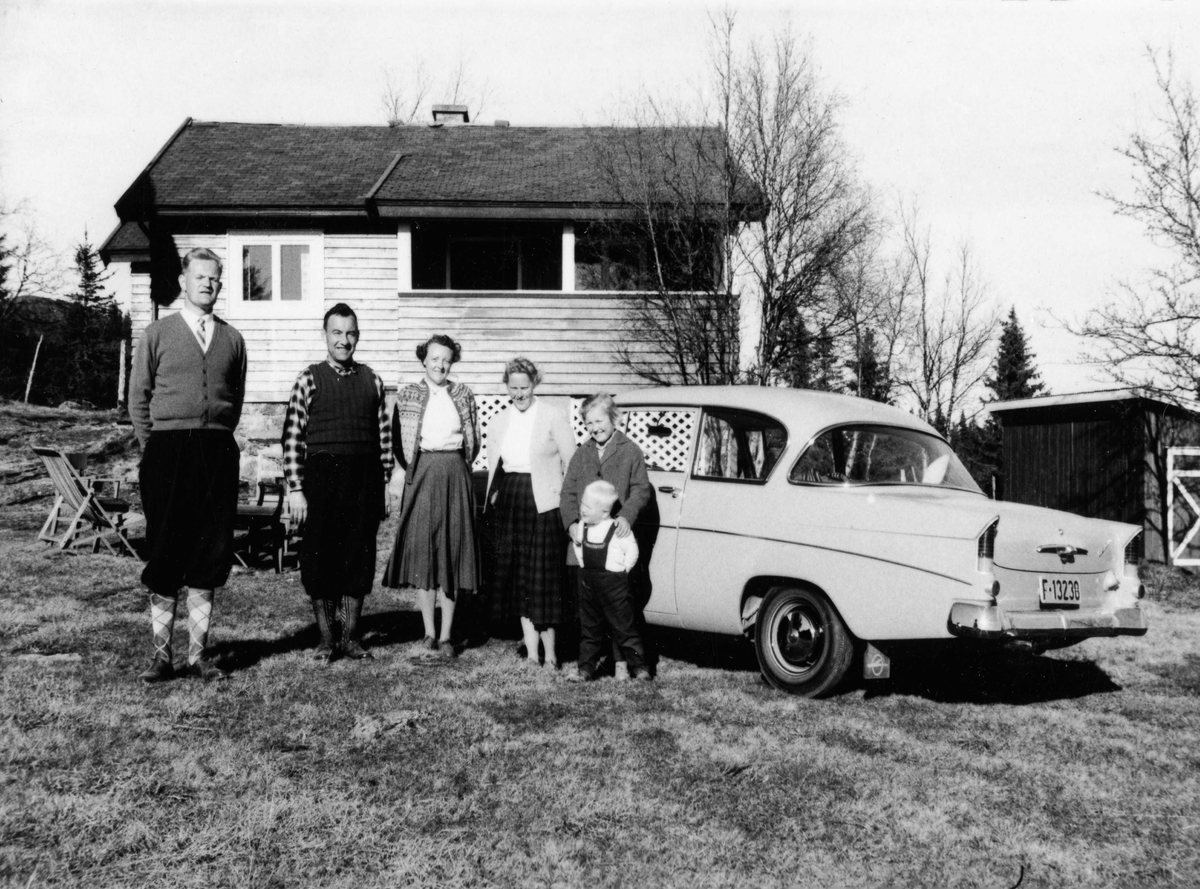 Gruppebilde utanfor hytta til Olav og Klara Slåtto.
Frå v.Olav Sevre,Olav Slåtto,Klara Løstegård Slåtto,Ruth Hagen Sevre og Toril Sevre med Arne Sevre framfor seg.
Bilen er ein Opel 1500 1961-62.