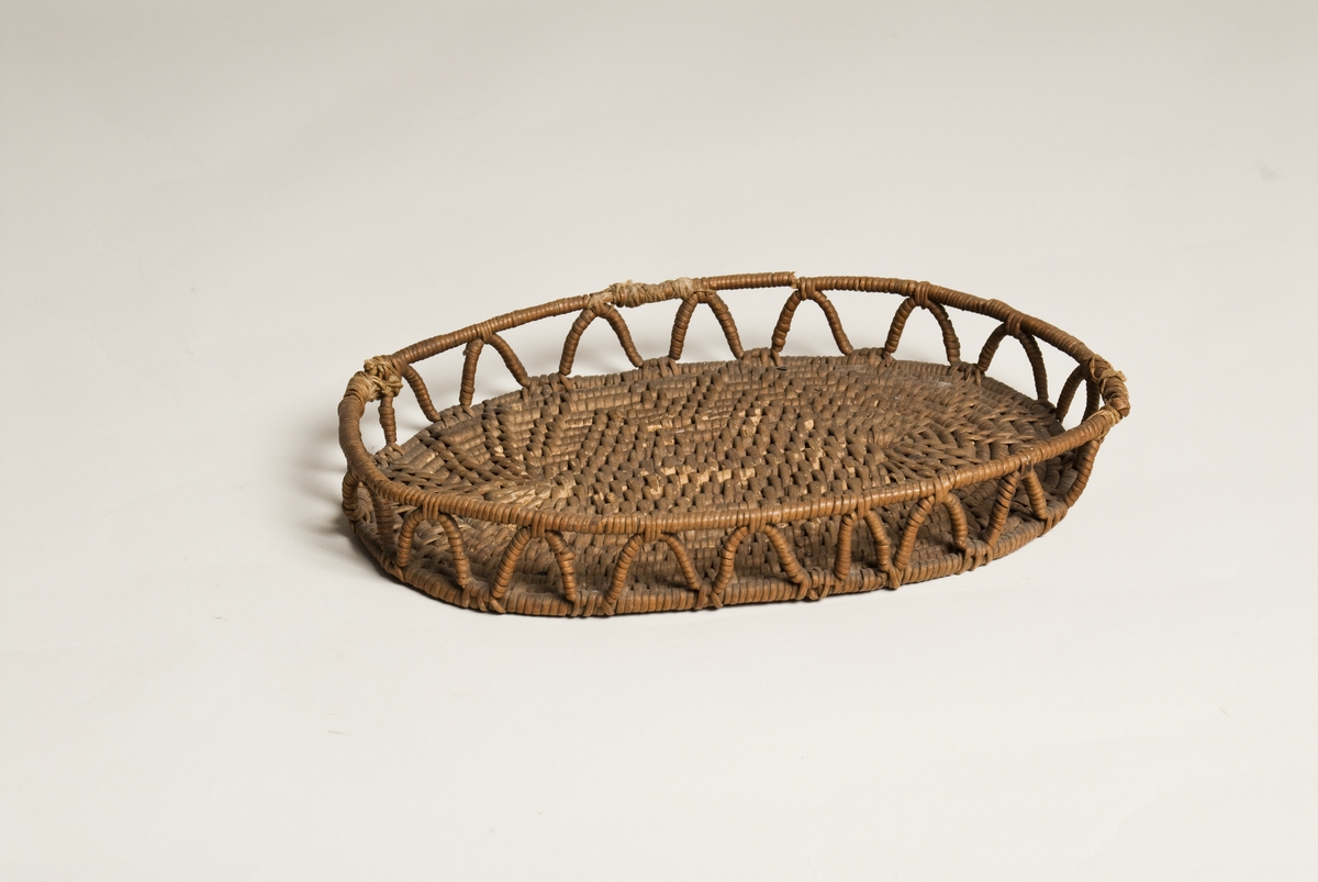 Oval brødkurv. Bunnen i tett mønsterbinding. Gjennombrutt side med siksak bord. 