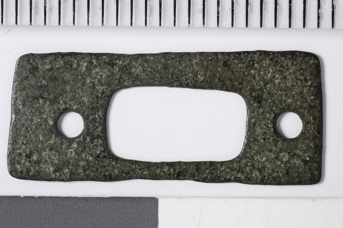 MALV: 22, 9 MM, BÅNDFORMET, KLIPPET ELLER STANSET UT AV METALLBÅND. ET REKTANGULÆRT OG TO RUNDE HULL. 