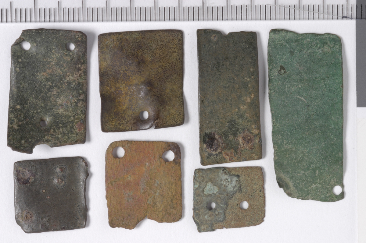 MALV: 15*13 - 26*17 MM, REKTANGULÆR BÅNDFORMET MED TO HULL I ENE ENDEN, AVBRUKKET I ANDRE. TO FRAGMENTER HAR ISITTENDE NAGLER OG ETT FRAGMENTHAR BARE ET HULL I ENDEN. 