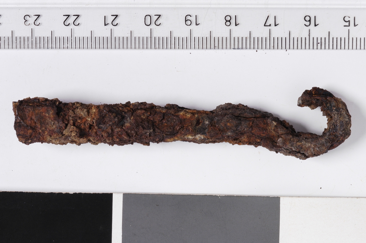 MALV: L. 8, 4 CM, ST. TYKKELSE 1, 1 CM, AVLANGT JERNSTYKKE M. KVADRATISK TVERRSNITT, TRUKKETUT I EN KROK PÅ ENDEN. 
