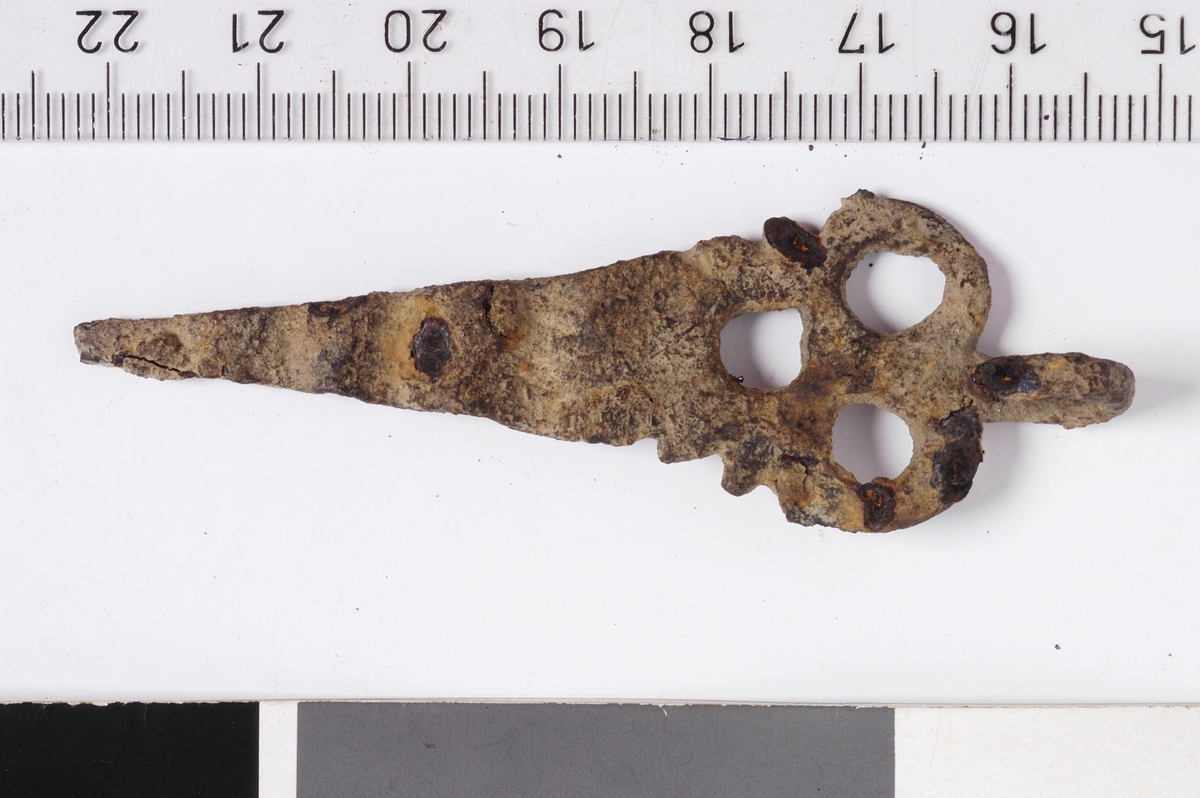 MALV: L. 7, 0 CM, ST. B. 2, 2 CM, TREKANTET, LANGSTRAKT FORM M. TRE HULL I DEN BREDESTEENDEN. DEN SMALESTE ENDEN ER BØYD I BØLGER. I DEN BREDESTE ENDEN ERDET ET ØRE TIL OPPHENGING. 