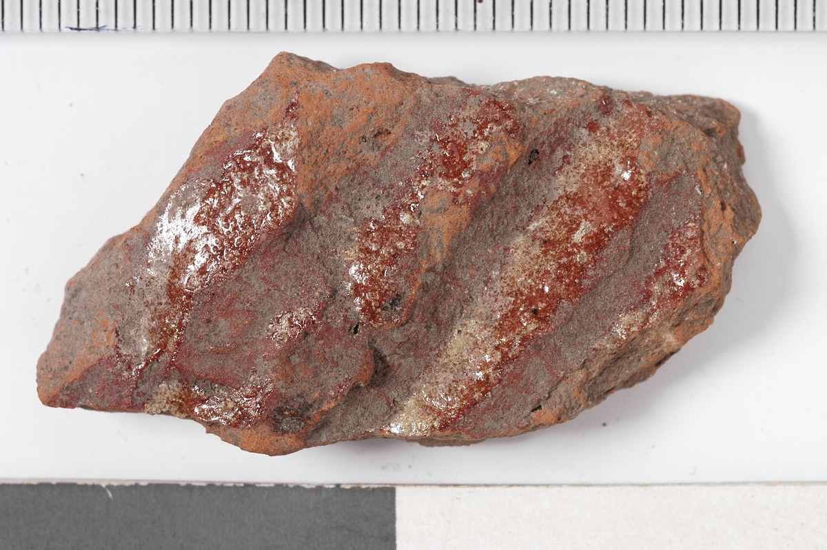 UTSIDE, CA 0, 5 CM BREDE VULSTER M, SPOR AV GLASUR. INNSIDE RØDBRUN GLASUR M. NOE SPETTER. 