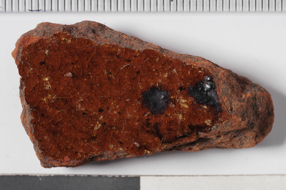 MÅL: TYKKELSE GODS 1, 0 CM, INNSIDE BRUNRØD GLASUR M. MØRKE SPETTER, UTSIDE M. FLEKKER AV GLASUR.