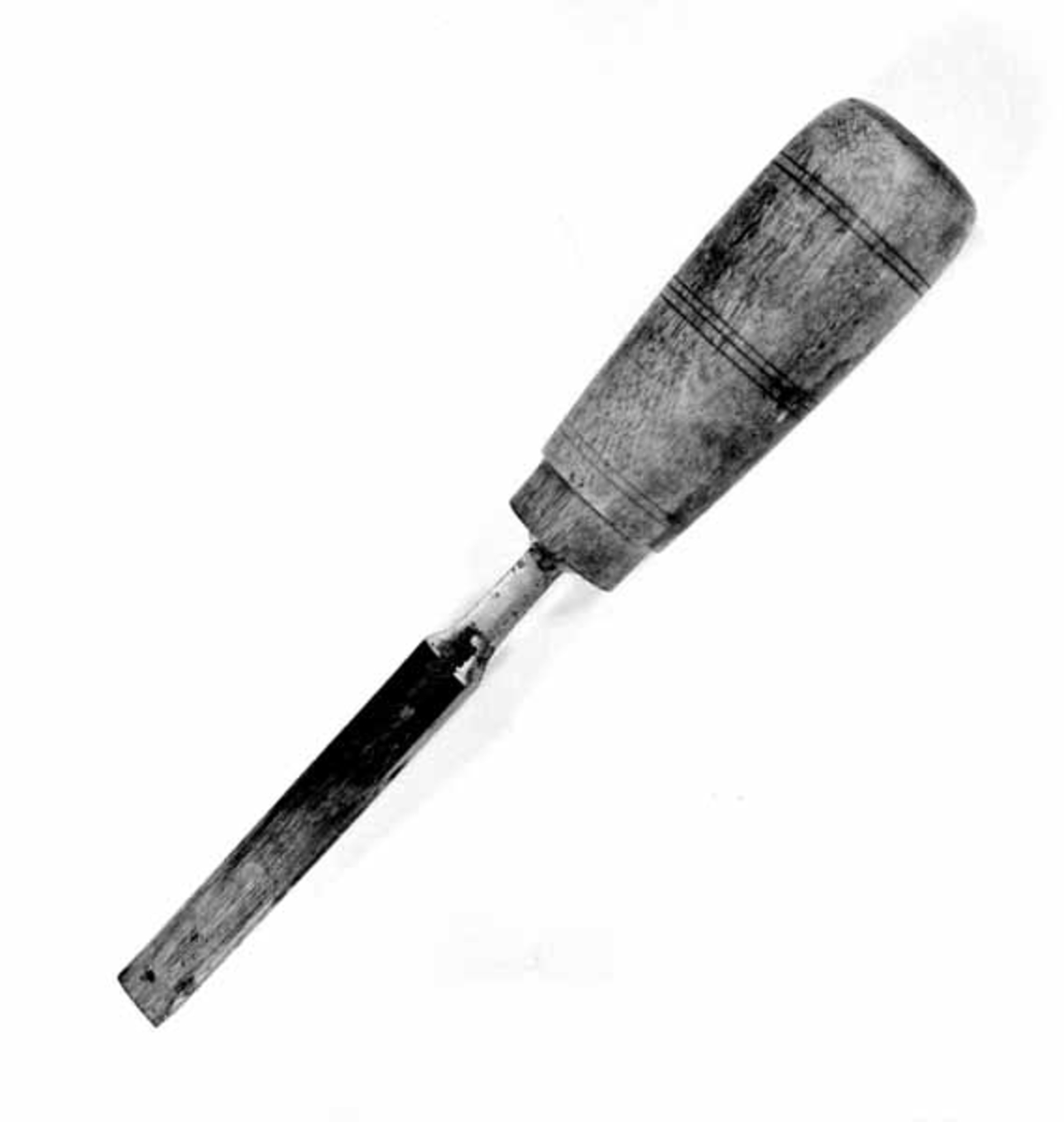 Stemjern, brukt til å skjære eller stemme i et arbeidsstykke av tre med sikte på å gi det en ønsket form. Dette redskapet er 21,9 centimeter langt. Den synlige delen av stålet, klingen og en krage (avsats) mot den nedre enden av skaftet, er snaut 12,2 centimeter lang. Klingen er flat, og har med andre ord et rektangulært tverrsnitt. Den fremre enden er fasslipt fra oversida. Umiddelbart ovenfor denne slipefasen er klingen drøyt 1,3 centimeter bred og 3 millimeter tjukk. Fra dette punktet og bakover/oppover avtar bredden en aning, samtidig som tjukkelsen øker til 5 millimeter. Fra et punkt drøyt 9 centimeter bakenfor/ovenfor eggen er det en symmetrisk, konkav innsnevring i klingens bredde. Overflata på den nevnte kragen har åtte faser. Kragens yttermål er 1,3 X 1,3 centimeter. På oversida av kragen, i forlengelsen av klingens midtakse, må det være en spiss jerntein, en tange, som forankrer stålet i skaftet. Skaftet er lagd av tre, antakelig av bjørkevirke som er impregnert med et brungult fargestoff. Det er runddreid. Diameteren tiltar noe fra den fremre mot den bakre enden. Den ellers glatte overflata er prydet med inndreide striper - tre på midten og to i hver av endene. På den fremre delen av skaftet er det inndreid en 1,1 centimeter bred og om lag 1 millimeter djup og avsats, antakelig med tanke på en metallholk som skulle forebygge at treet sprakk når tangen ble drevet inn kjernen av skaftet. Det fulgte ikke med noen slik holk da dette redskapet ble avlevert til Norsk Skogbruksmuseum.