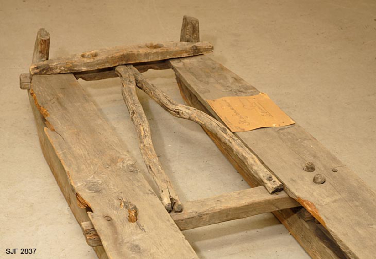 Gjenstanden består av to deler: slede og skjæker (drag). Materialet i sleden er i hovedsak ubehandlet gran.  Skjekene er også lagd av ubehandlet gran. Bakerst på undersiden er de utstyrt med jernbeslag. Humulen er felt inn i skjekene og er festet med treplugger.  Hutreet er laget av bjørk. Sleden har to fjetrer som hviler på 8 centimeter høye fjetrestamper. Den forreste fjetrestampen på venstre side mangler. Fjetrene er festet til meiene ved hjelp av store stallbandpinner. På hver langside er det festet en ca 20 cm bred fjøl oppå fjetrene i hele sledens lengde. Meiene er tykke og solide og de er tstyrt med treskoninger. Mellom forreste fjetrren og hutreet er det to bjørkestenger som er festet i kileform. Hutreet har to hull (5,5 x 4 cm) til å feste skjekene (skjækene) i.  Sleden er på enkelte steder ganske oppråtnet. Skjekene (skjækene) er også laget av ubehandlet gran. Bakerst på undersiden er de utstyrt med jernbeslag. Humulen er festet inn i skjekene (skjækene) med treplugger.. Den har to jernbeslag med lenker til å feste i hutreet på sleden.