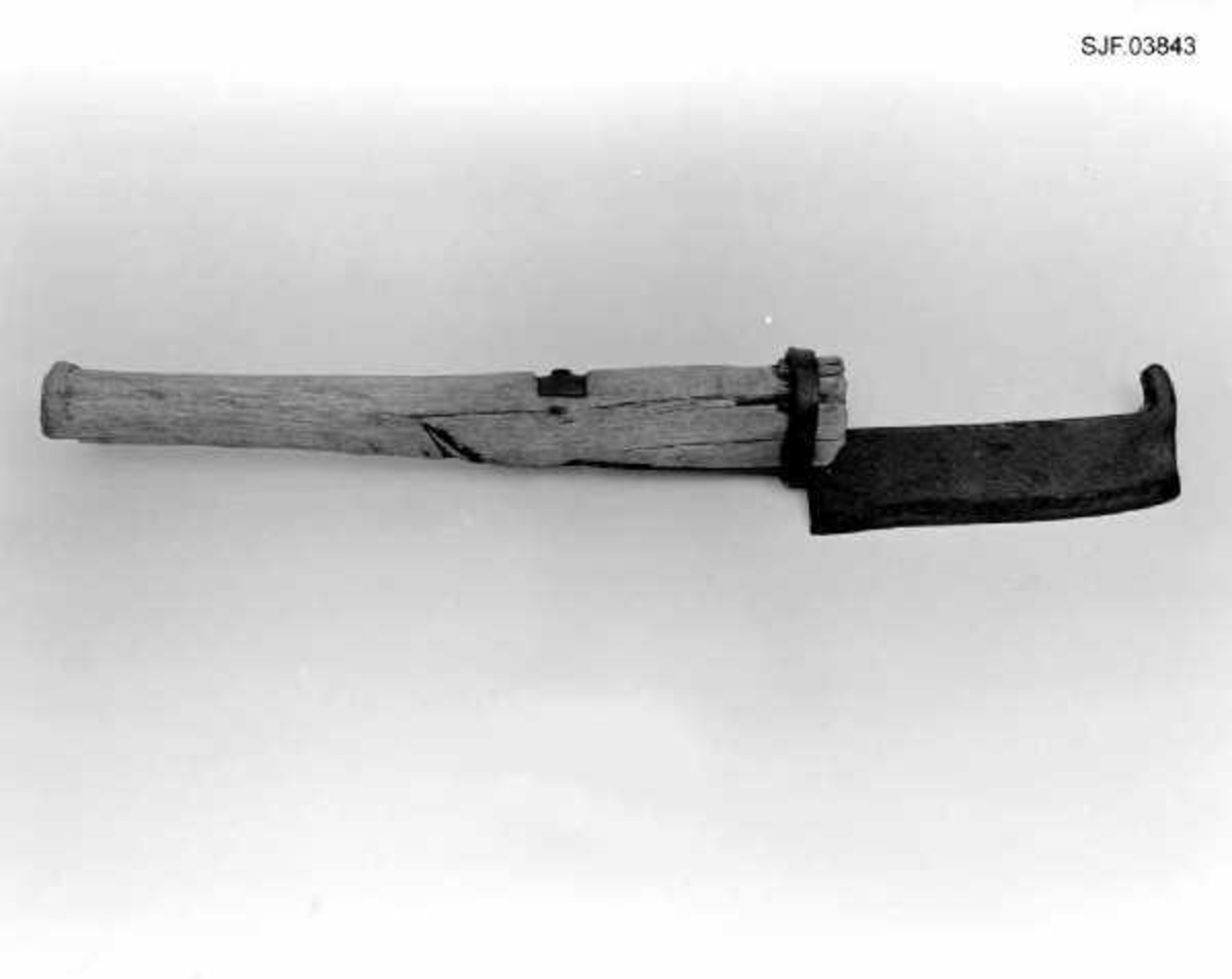 Lauvkniv, altså et redskap som ble brukt under innsamling av lauv som husdyrfôr. Redskapet er 47,5 centimeter langt. Knivbladet er 15,8 langt og 4,0-4,3 centimeter bredt. Bladryggen er 8-9 millimeter tjukk. Eggepartiet er fasslipt fra to sider. I den fremre enden av knivbladet er det smidd en oppovervendt krok (cirka 2 centimeter lang), antakelig for at brukeren av kniven skulle hekte denne over kvisten og trekke den ned i en rekkevidde der det var bekvemt å lauve. Skaftet er snaut 33 centimeter langt. Det er grovest i den fremre enden, men har også en markert endeknopp i den bakre enden. Tverrsnittet er ovalt. Skjeftinga er løst ved at en tange i enden av bladet er felt inn i et snaut 12 centimeter langt spor på den fremre delen av skaftbuken. Fra enden av dette sporet er den vinklete enden av tangen ført gjennom et hull i skaftet. Ytterenden er stuket mot ei jernskive på ryggsida av skaftet. Den fremre enden av tangen holdes i posisjon av en smidd jernring som omslutter både tangen og skaftenden. Veden i skaftet har sannsynligvcis krympet litt, noe som har gjort det nødvendig å sette inn en liten trekile mellom ringen og skaftet.