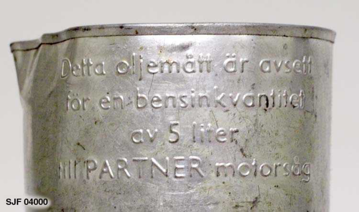 Verktøysett til motorsag av typen «Partner C6». Verktøyposen er sydd av grønn- og hvitstripet lerret. Posen er skitten, antakelig på grunn av oljesøl.  Den inneholder skruholder, to pluggnøkler med tverrstang, to settnøkkler, løst filskaft, fil, skrutrekker, umbraco-nøkkel, fettpresse, bensinlokk, to målebeger for olje, trakt og diverse smådeler.