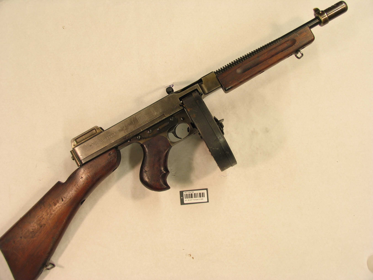 MED REM, OG EKSTRA PISTOLGREP FORAN. MERKING: THOMPSON SMG
CAL .45, AUTOMATIC CARTRIDGE, AUTO-ORDNANCE CORPORATION,
NEW YORK, N.Y. U.S.A., TRADE MARK THOMPSON REG US PAT. OFF P
FLAMMEDEMPER MERKET: CUTTS TRADE MARK (I ROMBE),
PAT. JULY 19 - 1927 NO. 1.636.357,
PAT. NOV   2 - 1928 N0. 1.615.383