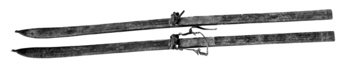 Hoppski av svartmalt hickory. 
De er dekorert med 6 renner, 2 på hver side og 2 i midten. Skiene harstillbare bindinger. Begge har tåreimer, mens bare den ene har hælbinding. Denne har ei reim som er beregnet til å gå over skoen nær leggen. Det har vært skoplater, men disse mangler. Under bindingene er det på begge skiene et flatt hull hvor det er innsatt en bleig el. trebit. Hullet er 4, 5 cm langt og 0, 7 cm bredt. Hullet viser at skiene har hatt en annen binding tidligere. 


