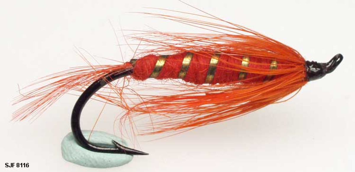 Lakseflue med sort krok og oval tråd, den har også et oppadbøyd øye. 