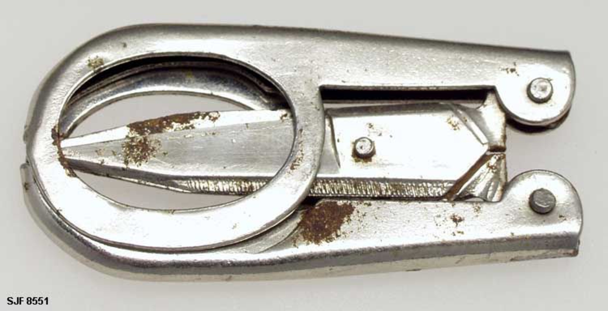 Lita, sammenleggbar saks, muligens fra stoppesett for reisebruk, kanskje også anvendelig til klipping av negler. I utfoldet stand er saksa cirka 10,5 centimeter lang. Bladene er 3,4 centimeter lange, målt fra sentrum av skruen som hengsler dem sammen, cirka 5,5 centimeter lange målt mellom bladspissene og endene der hendlene er pånaglet. Bladene har svakt konvekst buete, men nesten rette egglinjer. Nakkepartiene er konvekse, med riflete skråfaser. Hendlene er stanset ut av ei 1 millimeter tjukk stålplate og delvis falset slik at de fremre enden omslutter de bakre endene av bladstålene. Her er komponentene sammenføyet ved hjelp av nagler i overgangsonene mellom blader og armer. Dette gjør at bladet kan bøyes inn i øverste del av armen (lommekniv-prinsippet). Hendlene har ovale fingerhull. Den ellers blanke metalloverflata har noen små rustflekker.