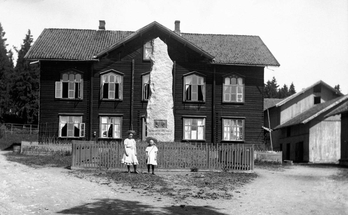 Hamar, Sagatun folkehøgskole, undervisningsbygget, bauta over grunnlegger Herman og Mix Anker, reist i 1901, to piker i forgrunnen,