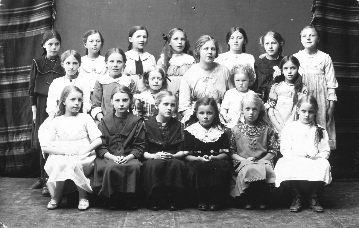 Metodistkirken i Hamar. Sødagskoleklasse ca. 1920. Foran f. v. ukjent, ukjent, ukjent, ukjent Ella Lund Hansen, Guvor Hedemann (Nyberg), ukjent. 
I midten fra v. Ukjent, Juline Johannessen, ukjent, Inga Iversen (Jacobsen) ukjent, ukjent. Bakerst f. v. Ukjent, ukjent, Solveig Rustad, Julie Jacobsen, ukjent, ukjent, ukjent. Klassens lærer er Inga Jacobsen f. Iversen