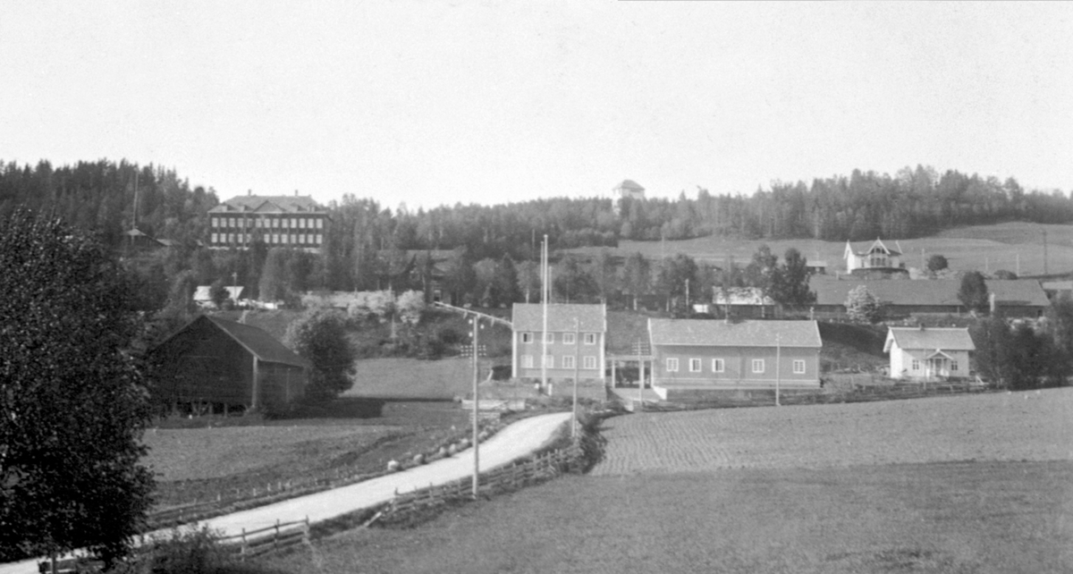 Ringsaker og Nes kraftanlegg med eindommen Nordal til høyre, Ringsaker stasjon, Ringsaker Fylkesskole (1914- brant1928) og eindommen Sole oppe til høyre oppført for styrer ved Ringsake Amtsskole O. A. Ophaug,