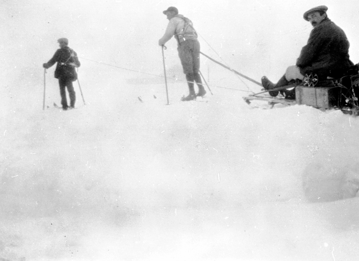 To menn drar kjelke. Jacob Nielsen sitter på. Påskeferie på Nysætra. Påskeferie på Nysætra.