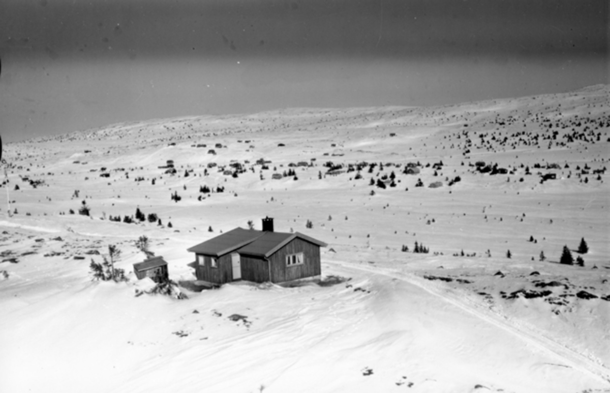 Flyfoto av bebyggelse i vinterlandskap på Sjusjøen, Ringsaker Almenning.