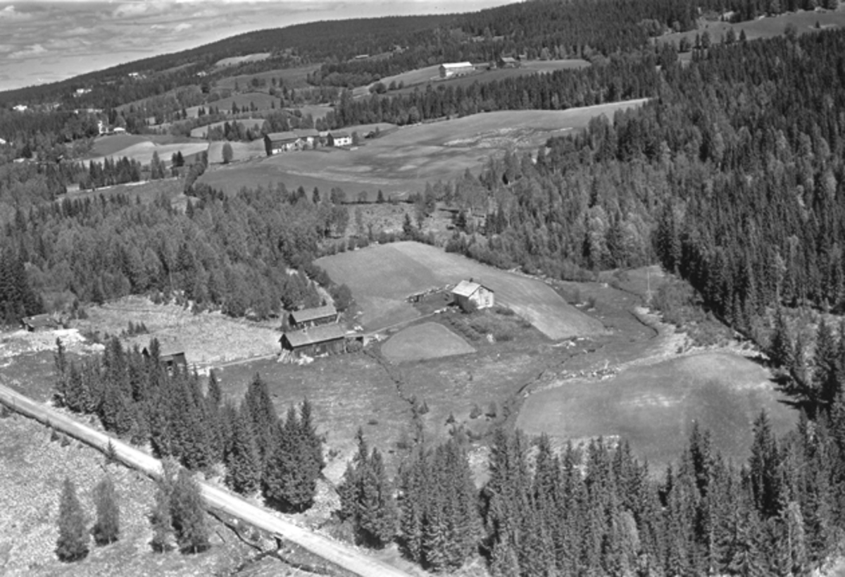 Flyfoto av Nybygda, Ringsaker. Bruket i forgrunnen er vel Jonsdal i Nybygda. Lenger bak er Aasdal og litt opp til høyre, Mæhlumsseter. Vegen mellom Nybygda og Putten nederst i venstre hjørne.