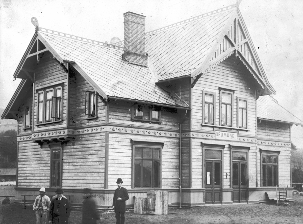 Eksteriør, Brumunddal jernbanestasjon, 5 menn foran stasjonsbygningnen.
