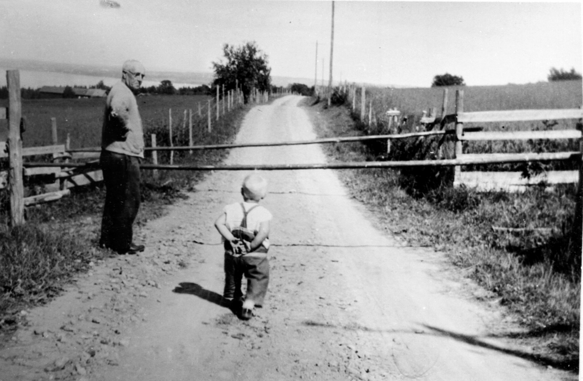 Karl Køpke (1862-1951) på Heggen, Helgøya sammen med en av sønnene på bygdevegen. Køpke hadde Heggen fra 1928-35. Han var blikkenslager fra Oslo.