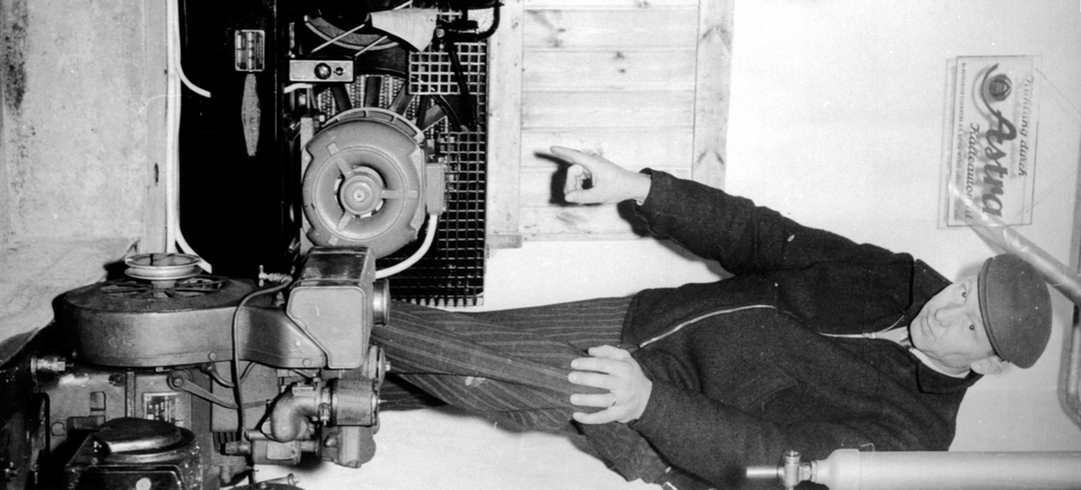 Gårdbruker Christian Sandberg f.1928 viser kjøleanlegget til det første gardstankanlegget for kjølt melk i Norge på Hoel gård, Nes, Hedmark.