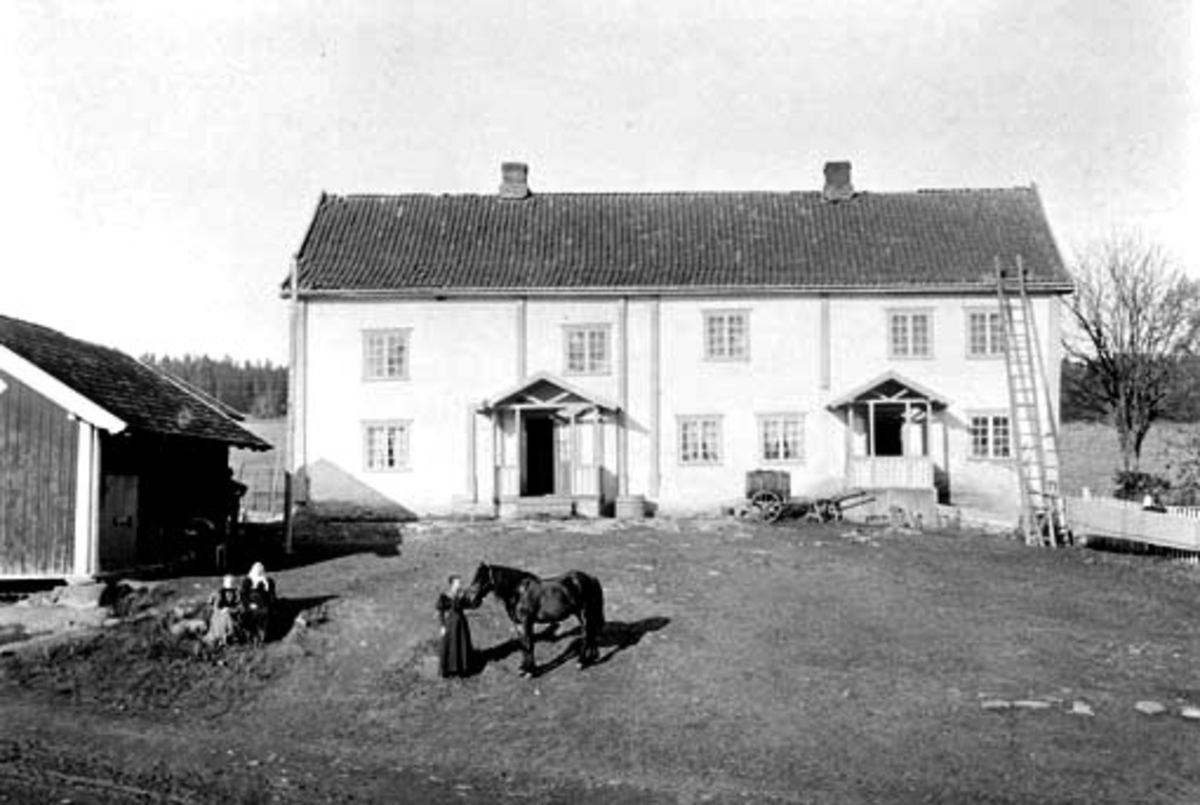 Eksteriør, gardsbruk. Mølstad østre, Nes, Hedmark. Tre personer på inntunet. Karen f.1880 og Petra Andersdatter f.1877 og trolig deres mor Agnete Johannesdatter (1844-1924).