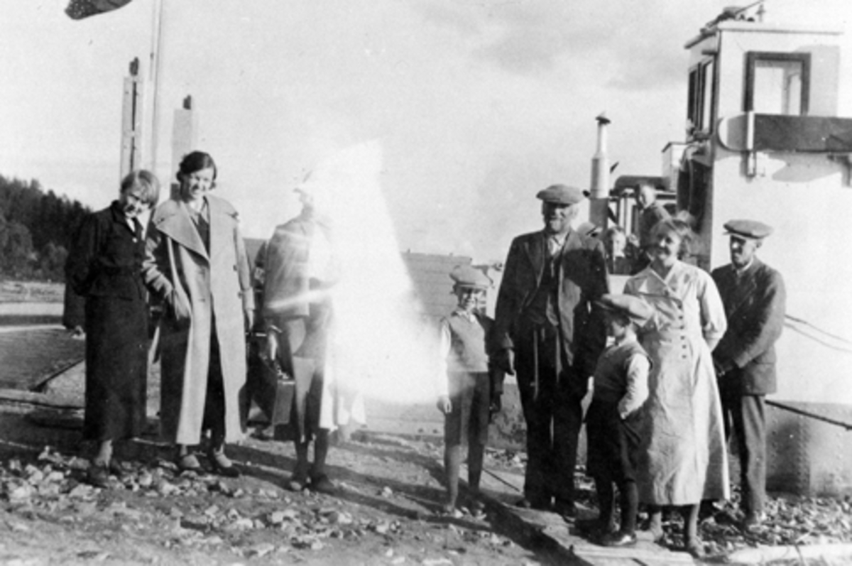 Nes, mjøsbåten M/F Mjøsfærgen ved brygga på Smedstuen nedre, Fra venstre er Mary Lie (1898-1981), ukjent, ukjent, Even Lie Jr (1928-1990), Even Arnt Andreassen Lie (1865-1938), Arne Wedrik Lie (1931-2007), Signe Lie (1902-1993), Arne Lie (1894-1989).