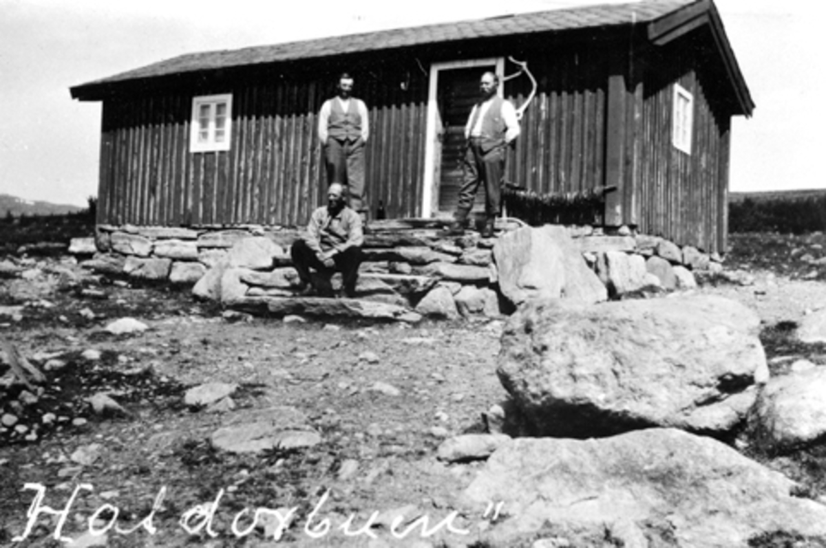 Eksteriør. Hestegjeterhytte i Ringsakerfjellet. Haldorbuen. Tre menn utenfor.