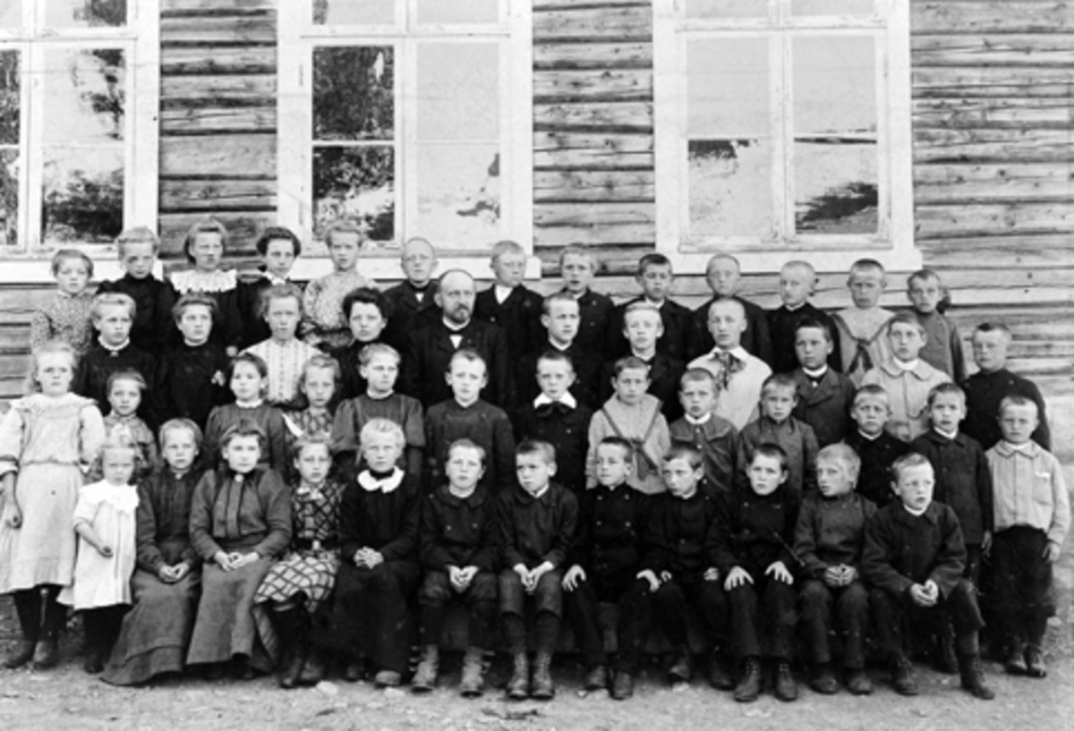 Elever og lærere ved Mauset skole ca. 1900. Første rekke bak fra venstre er Beate Granlien, Anna Nordhagen, Helga Berge, ukjent, ukjent, Johs Bakken, Georg Kjendli, Arne Rønningen, Olaf Øverli, Petter Bakken, Trygve Nilsen, Alfred Myhre, Olaf Stenset. Andre rekke er Oline Bakkerud, Mina Ås, Marte Bækkelien, Marte Bakken, lærer Mauset, Tore Nordsveen, Jørgen Bakkerud, Asbjørn Nilsen, Jørgen Bækkelund, ukjent, Martin Holter. Tredje rekke er Mina Sørlunden, Anna Sandbakken, Magnhild Mauset, Oline Bratlien, Ola Bækkelien, Birger Kurud, Birger Myhre, ukjent, Kristian Stenset, Georg Haugen, Arvid Sandbakken, Severin Myhre. Fjerde rekke (foran) Emma Eønningen, Marie Mauset, Pernille Bækkelund, Anna Sandbakken, Magnhild Vestlien, Marie Jevne, Børe Tørudstad, Adolf Sandbakken, Olaf Hovde, Kristian Haugen, Martin Jensbak, Even Sørlunden, Hans Granlien.