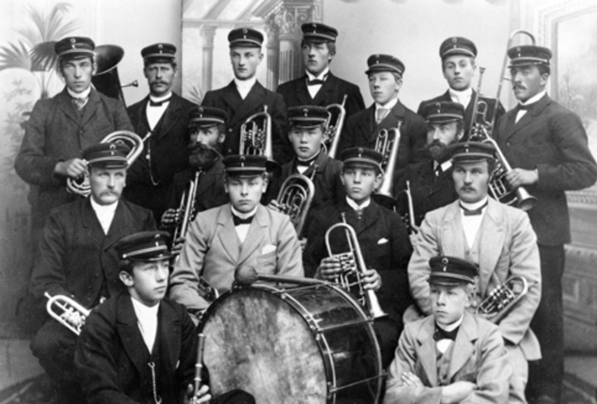 Moelv Musikkforening, ca. 1895-1898. Sittende foran er Otto Henig og Halfdan Grønvold. Andre rekke Simen G. Ruud, Lars Grønvold, Børre Skjønsberg og Anton Lysrud. Tredje rekke Peder Pedersen, August Pettersen og Even Eng. Fjerde rekke Petter M. Amblie, Johan Bjørke, Lars Pedersen, Fjeldhammer, Hans Rud, Sløttet, Julius Olsen, Ole Skar Jr. og ukjent fra Nes.