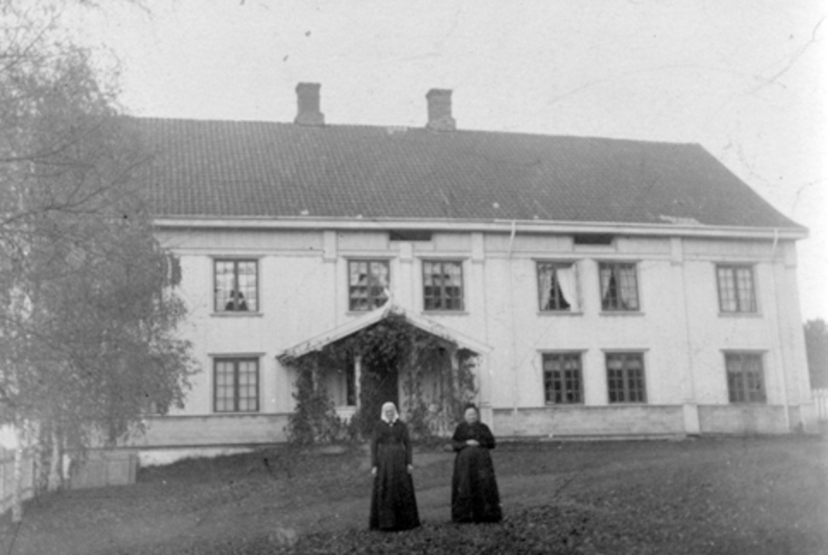 To ukjente kvinner foran hovedbygningen på Hoel gård, Nes, Hedmark.