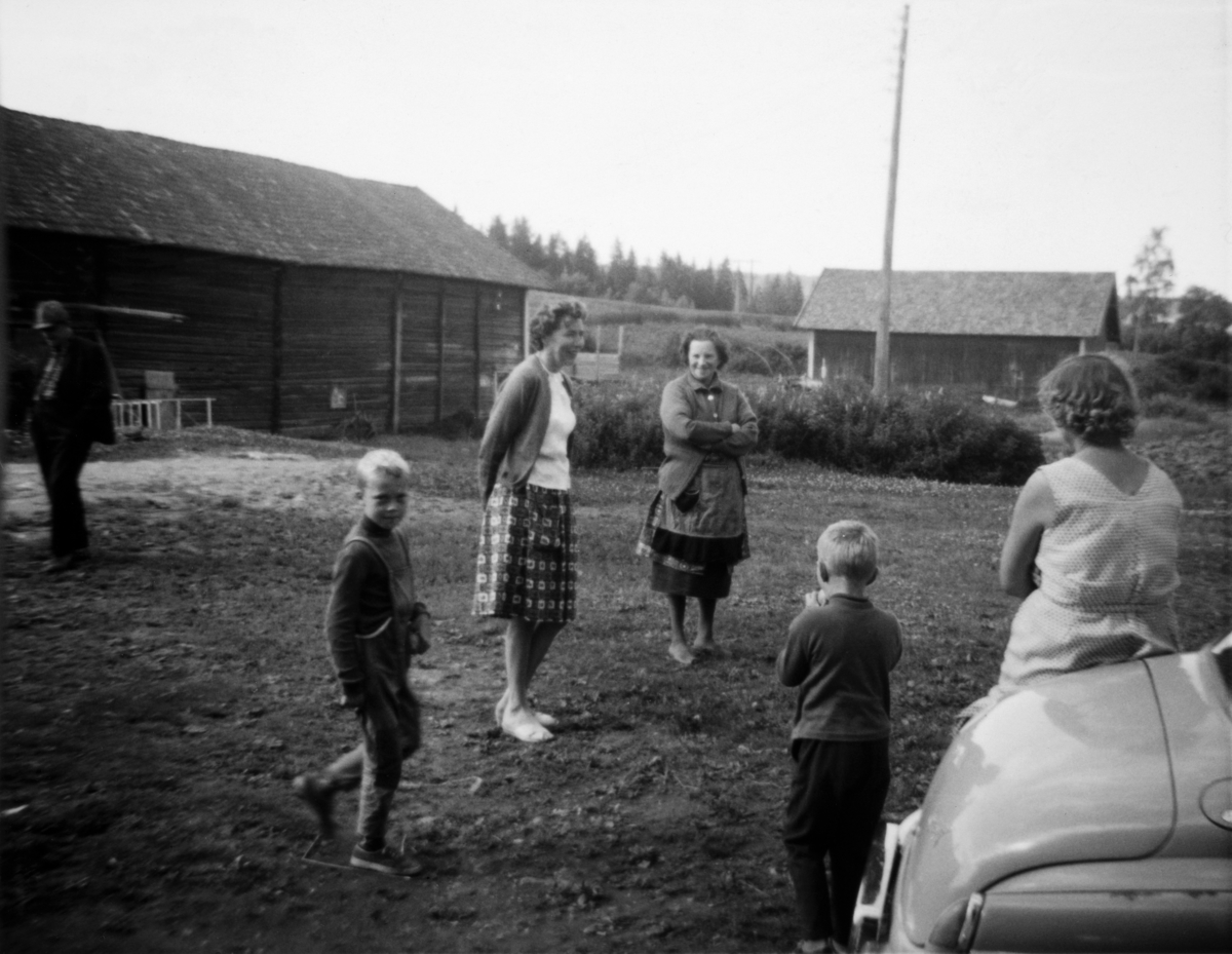 Fra gardsplassen på Øvre Slemsrud ca 1966. Fra venstre: Simen Haugsveen, Lars Erik Aamodt, Kjellaug (?), Anna Haugsveen. Med ryggen til står Nils Tore Aamodt og Ragnhild Aamodt. 