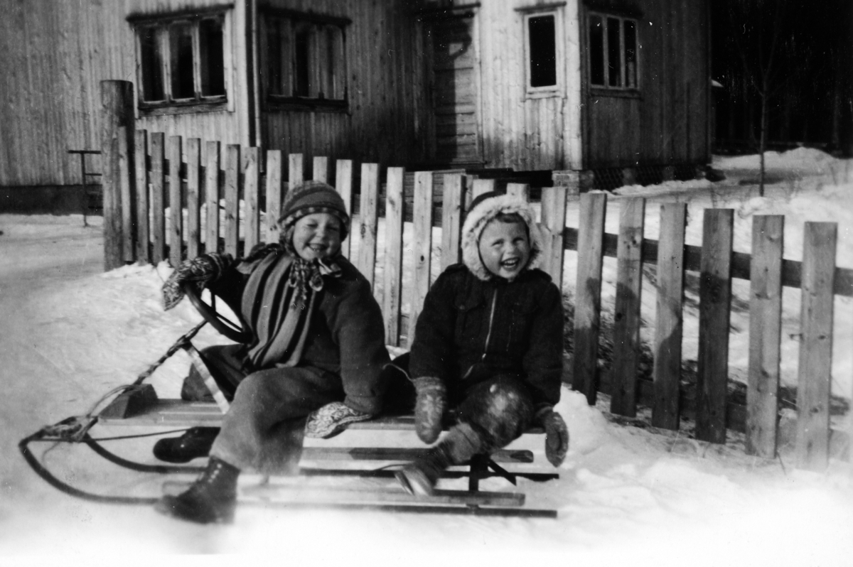 Reidar Bråthen og Oddvar Vestli på rattkjelke foran Fredbo i "Flisbyen" på Ilseng, ca. 1946. 