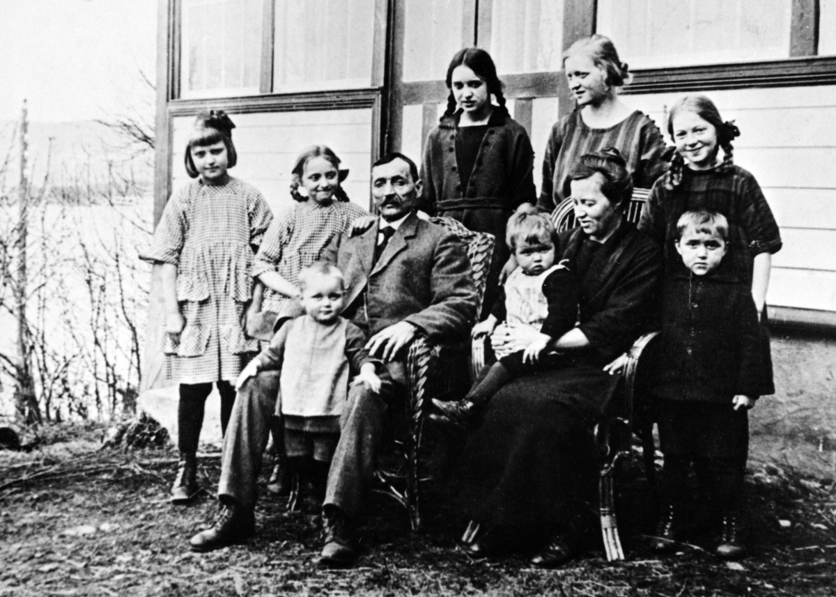 Mons Hestnæs med familie, drog til Amerika og kom tilbake ca. 1900. Bygde opp Baneminde. Alette, Else; Mons m/ Arne, Aslaug m/ Borger, Eivind. Bak Mary, Mabel og Gudvig. 