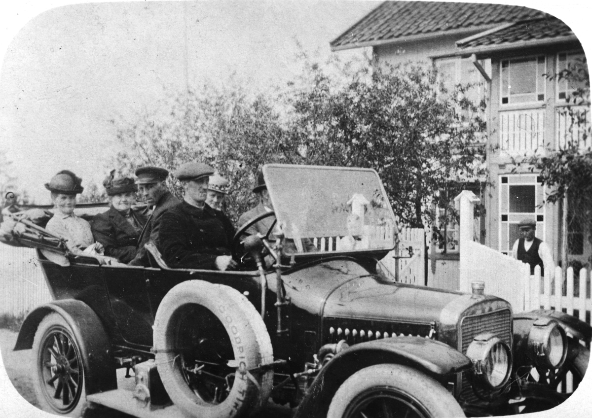 Bil. Merket er Adler. Årsmodell ca. 1910-14? Sjåfør Anton Nilsen Godtland. Bilen kostet 3000 kroner og ble brukt som drosje, taxi. Det kostet 50 øre fra Hamar til Kjonerud. Maxtakst var kr. 1, 50. 