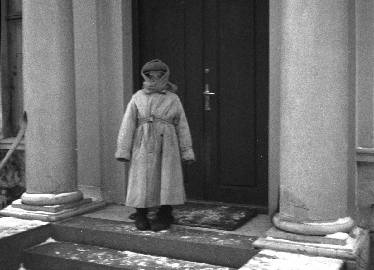 Atlungstad gård. Barn stående på trappen, innpakket i varme klær, før det skal være med på tur med hest og slede. Julen 1933. 