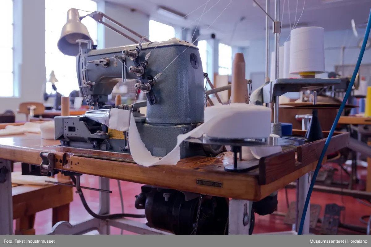 Rimoldi-symaskin som syr kantband til klede av strikka tekstilar (trikotasje). Ein kan sy med to og tre nåler og ein dekktråd. Ein tråd under ("looper"). Ein brukar band som er kutta til på ei anna maskin og rulla opp, plasserer ein enden av bandet i eit bandapparat i metall. Det blir så mata gjennom dette og sydd. 
Maskina er av klasse 1363 - 25.