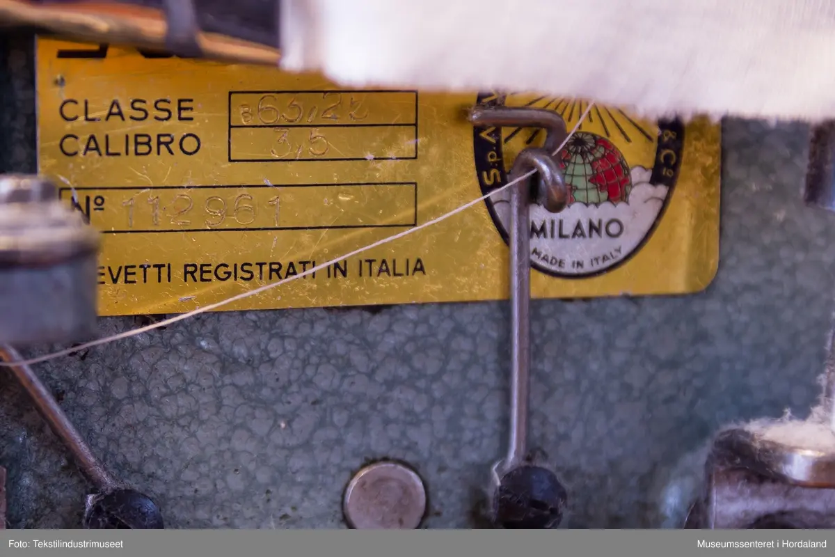 Rimoldi-symaskin som syr kantband til klede av strikka tekstilar (trikotasje). Ein kan sy med to og tre nåler og ein dekktråd. Ein tråd under ("looper"). Ein brukar band som er kutta til på ei anna maskin og rulla opp, plasserer ein enden av bandet i eit bandapparat i metall. Det blir så mata gjennom dette og sydd. 
Maskina er av klasse 1363 - 25.