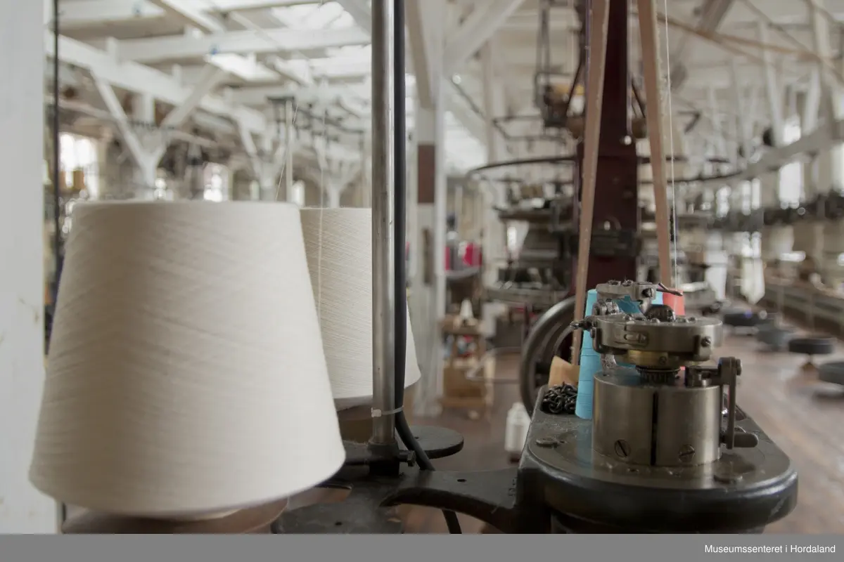 Rundstrikkemaskin med liten diameter frå Schubert & Saltzer Maschinenfabrik i Chemnitz i Tyskland, brukt på Salhus Tricotagefabrik utanfor Bergen. Maskina har berre 16 nåler, to trådar og ein trådførar, og vart truleg brukt til å strikke stay-band som gjorde saumane fastare.

Den har eit handtak på eine sida som ein kan bruke til å sveive maskina manuelt, og eit hjul på denne sida det maskina er kopla til reimdrifta i taket. Maskina har eit lite strykejern som stryk den ferdigstrikka "pølsa" etter kvart som den vert strikka. Strykefunksjonen er kopla til med elektrisk stikkontakt. Er dette ei forbetring som har komme i ettertid? Det kan òg tenkjast at det har vore ei rulle festa til maskina som rulla opp bandet direkte.