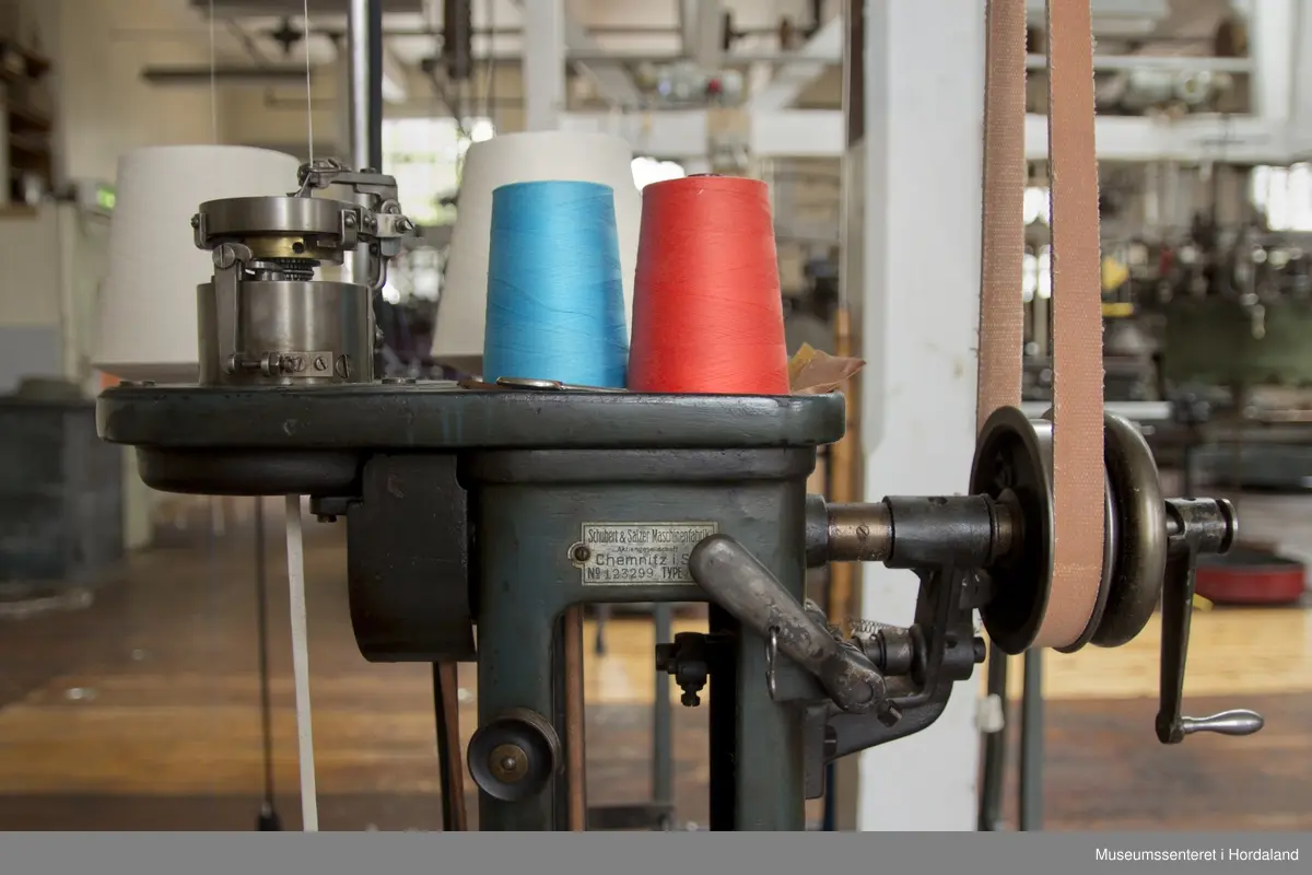 Rundstrikkemaskin med liten diameter frå Schubert & Saltzer Maschinenfabrik i Chemnitz i Tyskland, brukt på Salhus Tricotagefabrik utanfor Bergen. Maskina har berre 16 nåler, to trådar og ein trådførar, og vart truleg brukt til å strikke stay-band som gjorde saumane fastare.

Den har eit handtak på eine sida som ein kan bruke til å sveive maskina manuelt, og eit hjul på denne sida det maskina er kopla til reimdrifta i taket. Maskina har eit lite strykejern som stryk den ferdigstrikka "pølsa" etter kvart som den vert strikka. Strykefunksjonen er kopla til med elektrisk stikkontakt. Er dette ei forbetring som har komme i ettertid? Det kan òg tenkjast at det har vore ei rulle festa til maskina som rulla opp bandet direkte.