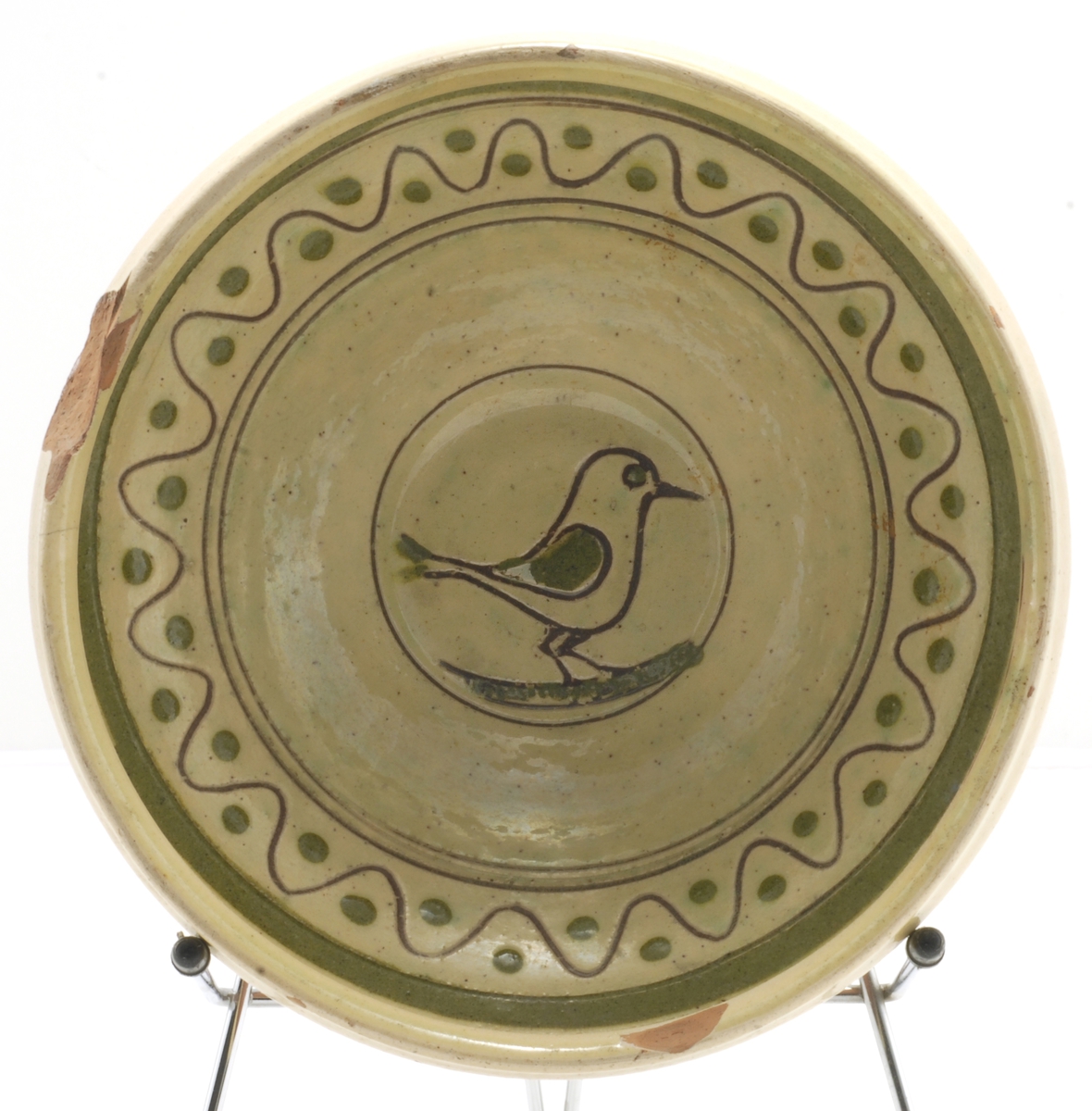 Skål med glassur innvendig og øvre del utvendig. Dekor i form av border og fugl i bunnen - risset og malt innvendig.