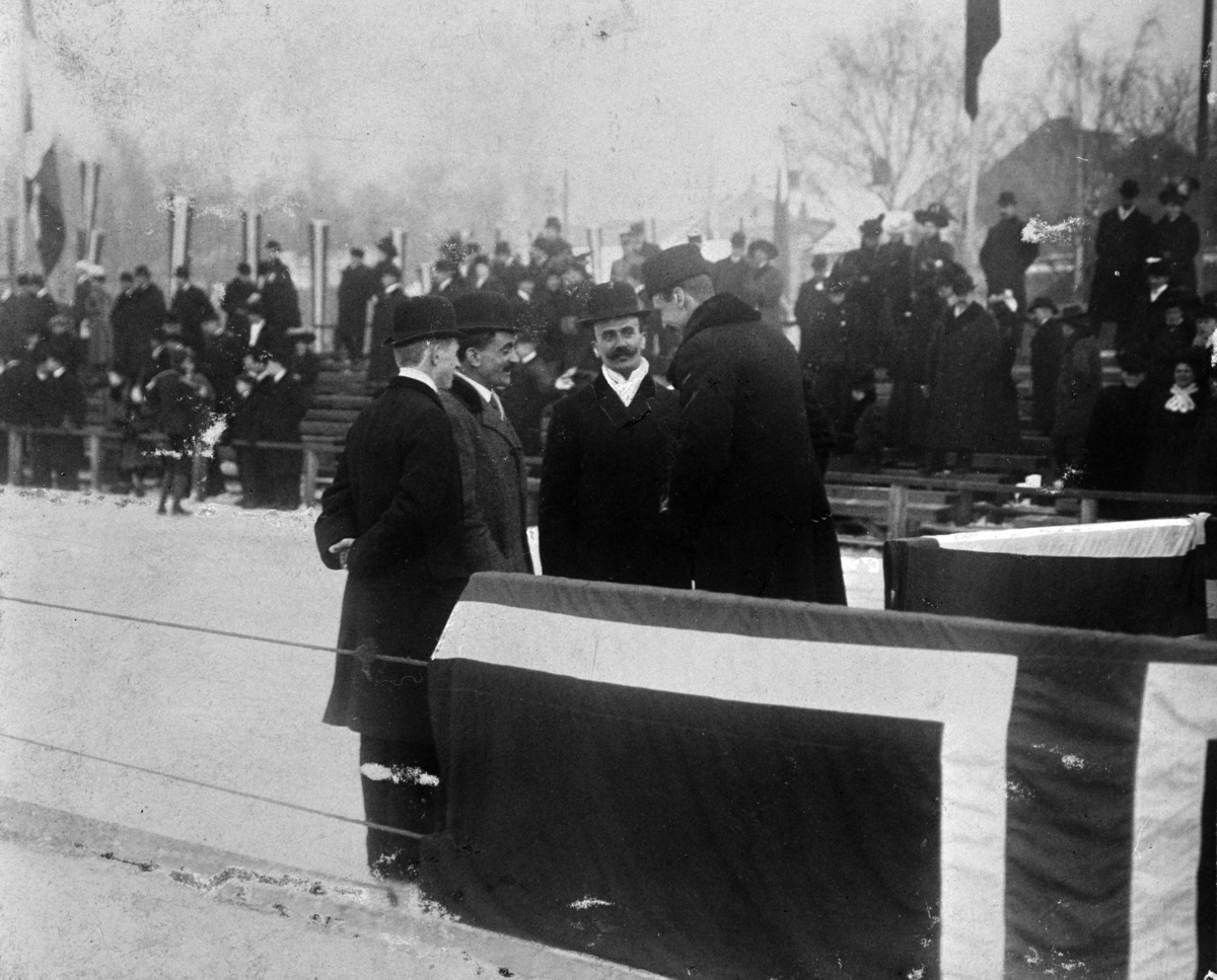 Skøyteløp på Frognerbanen i Oslo, 1909.  M. Johansen, Oscar Mathisen, Sigurd Mathisen og Kong Haakon i samtale ved kongetribunen. Oscar Wilhelm Mathisen (født 4. oktober 1888, død 10. april 1954) var en norsk skøyteløper som representerte Kristiania Skøiteklubb.