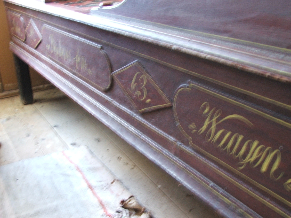 En skuvseng med 4 sengestolper og himling, utskjæringer ved sengevangene og øverst. Mangler forheng. Inskripsjon malt i gult foran. Himlingen er festa med tapper på sengestolpene.