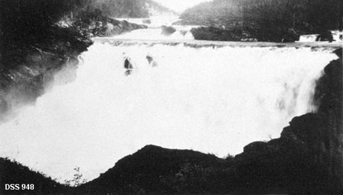 Storfossen i Røsåa i Hemnes.  Fotografiet viser et forholdsvis bredt, bratt og kvitskummende fossefall på et sted der elva gjør en sving i forhold til det ovenforliggende løpet. 