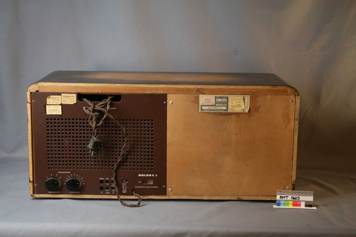 Rektangulær radio med horisontale striper i lysebrun og mørkebrun. Forside: høytaler med tekstiltrekk, skalal med fem funksjons-, og søkeknapper. Indikator på signalstyrken på stasjonen, kalles "trolløye". (Jo sterkere stasjonen er, desto større "øye". Elektronisk fluoriserende belegg.) Bakside: bakplate med knapper for bølgevender og avstemning. Uttak for grammofon, antenne, høyttaler, jord og strøm.