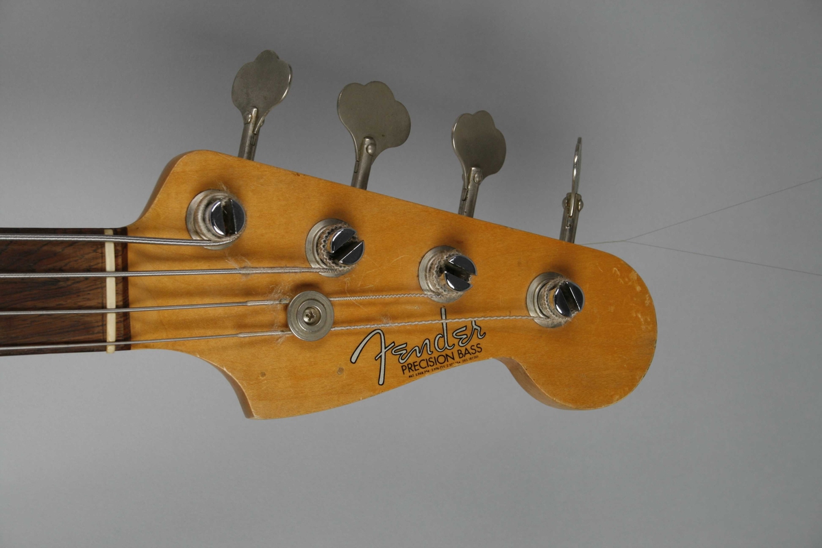 Korpus i lyst lakkert tre. Rødt plekterbrett. 20 tverrbånd på halsen. Volum- og bass/diskant (tone)- kontrollknapper. Split single-coil pickup. Skrue for reim på venstre sarg.