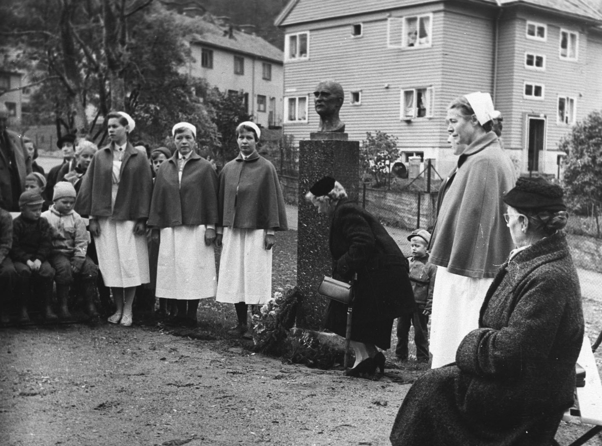 Gunvor Galtung-Haavik legg ned krans ved bysten av sin far dr. Jan Haavik ved Fylkessjukehuset i Odda.